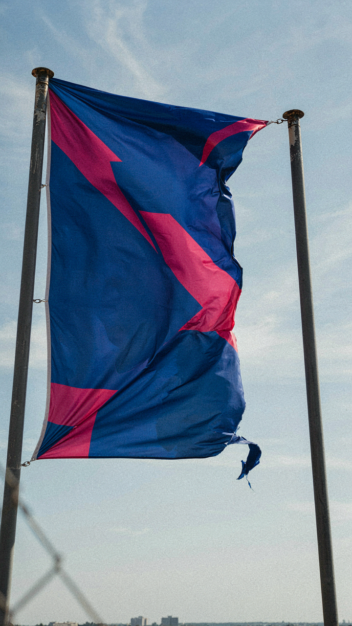 A big party banner flutters hard in the wind, about to rip.