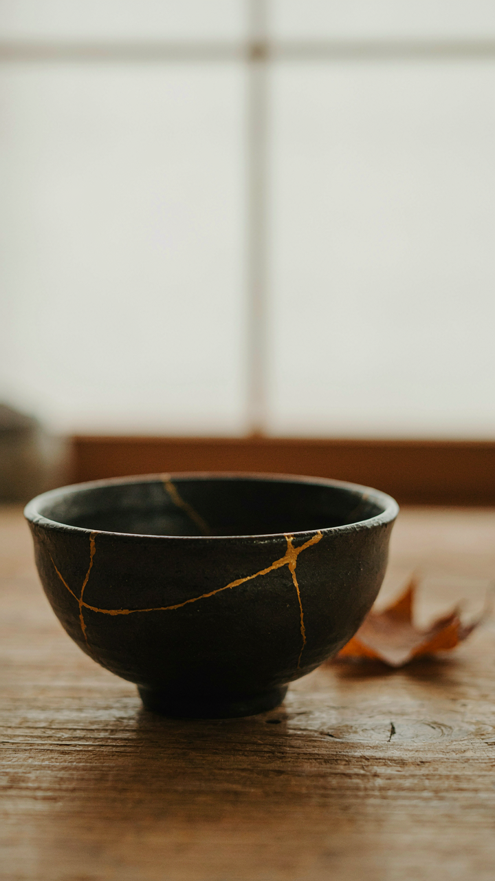 A Japanese kintsugi pottery bowl shows golden repairs that highlight imperfections.