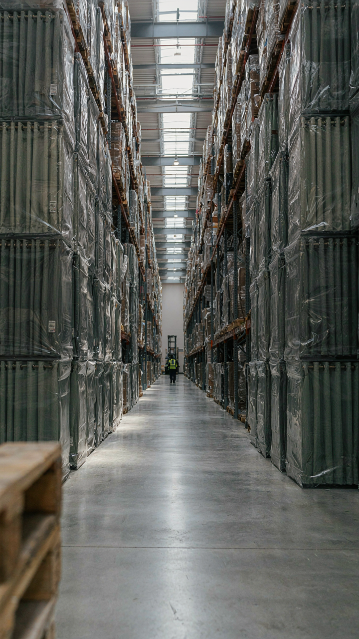 Many stacks of new, factory-made curtains in plastic packaging.