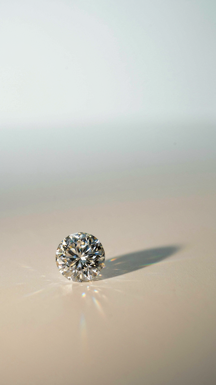 A clear, cut diamond reflects a rainbow of light.