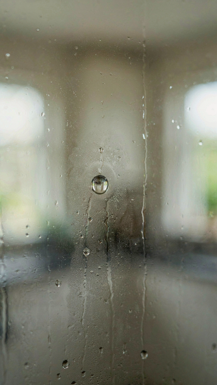 A clear bubble of still air clinging to a cold window pane.