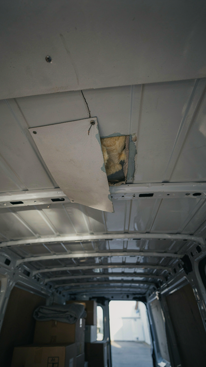 A ceiling panel in a moving van begins to pull away.