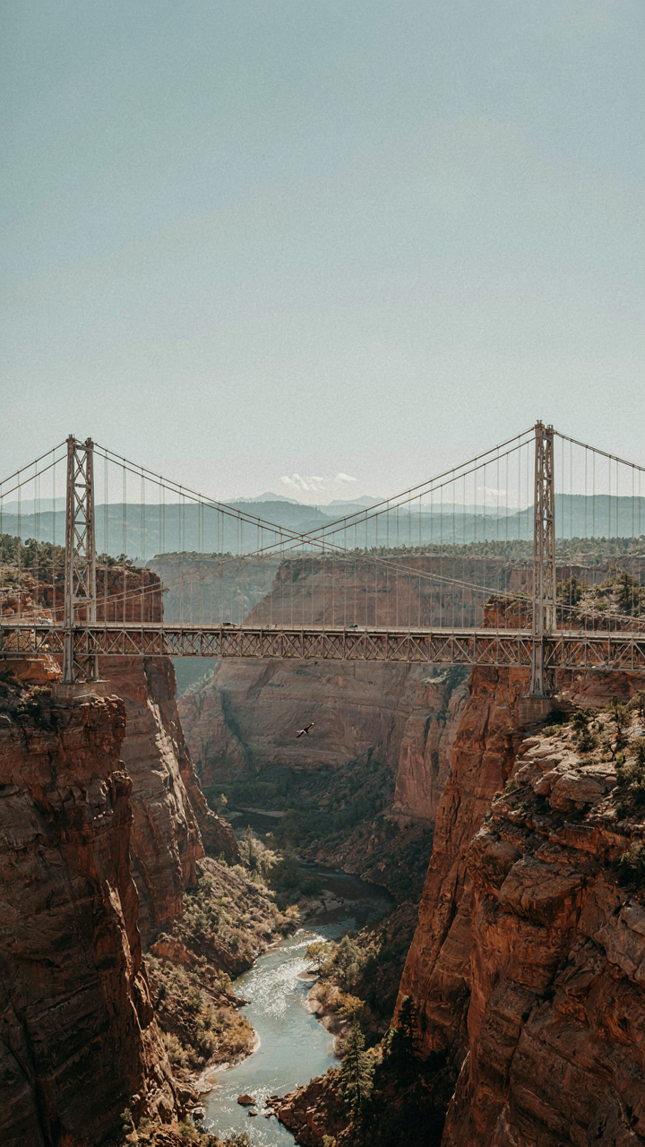 An engineered bridge crosses a wide canyon.