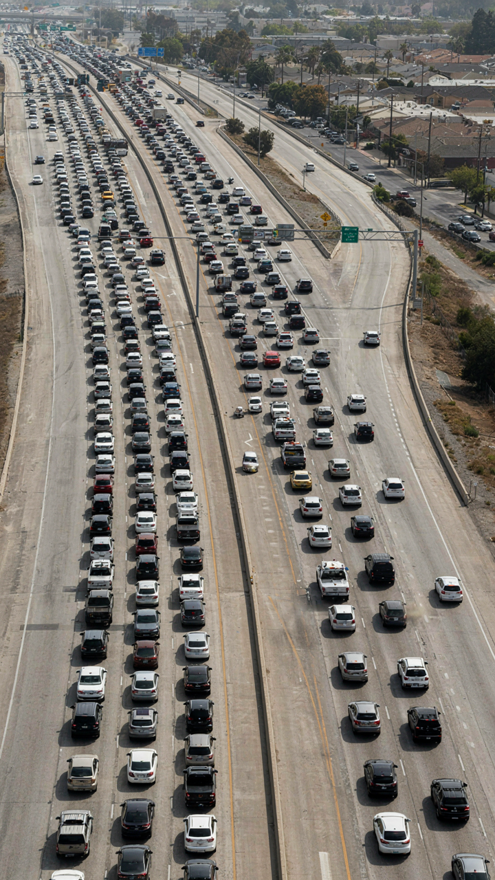 Many cars are stuck in a bottleneck on a highway during rush hour.