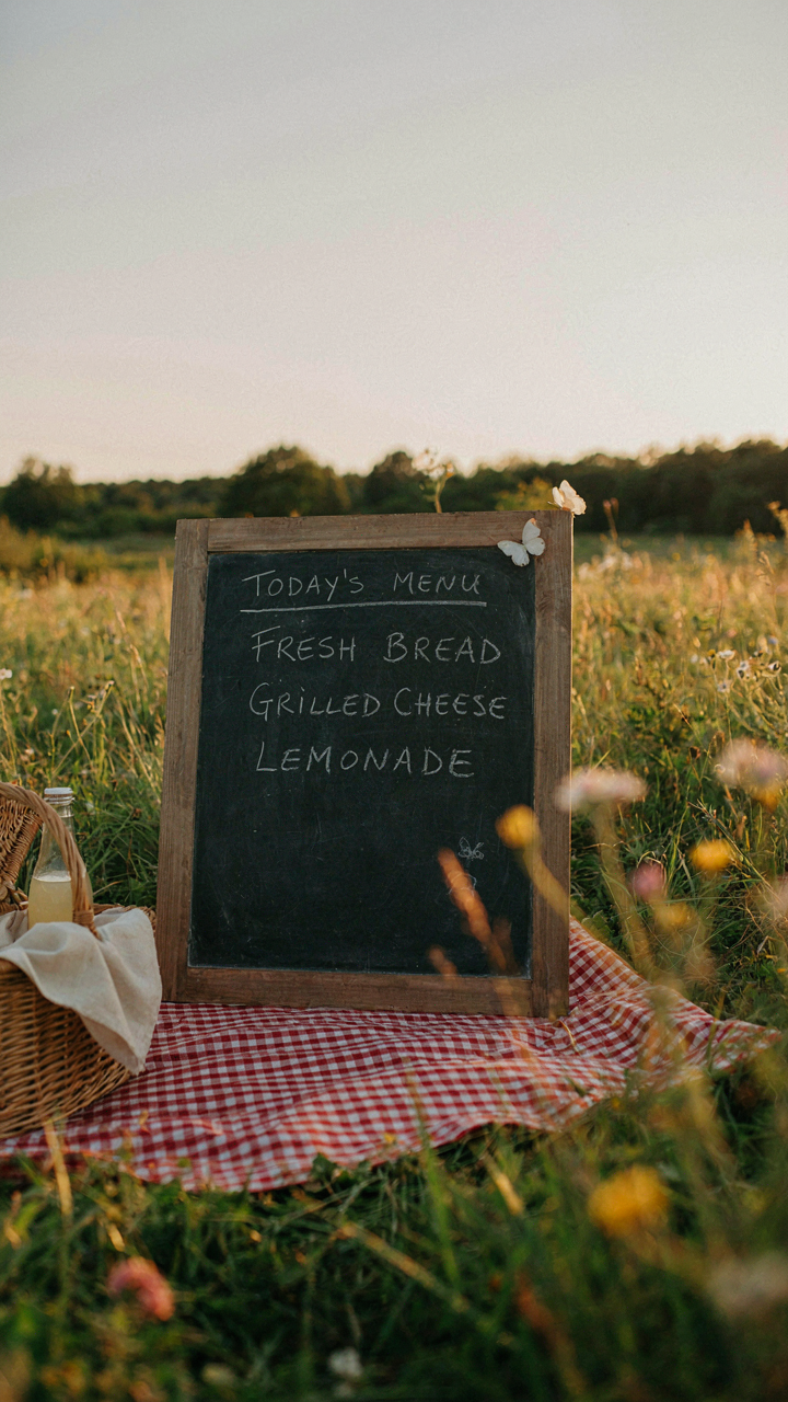 A chalkboard lists three simple food options for a sunset picnic idea.