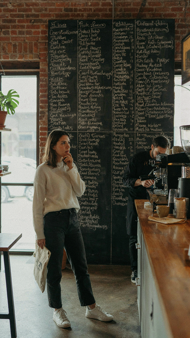 A person looks confused by too many drink options on a large menu board.