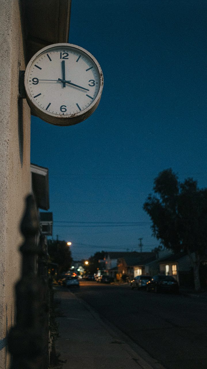 A clock on an outdoor wall shows 10 PM, signaling quiet hours.