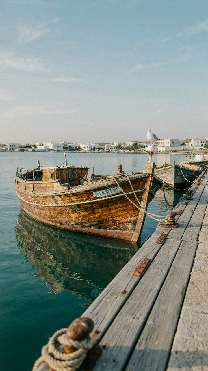 An old, sturdy wooden boat docked at a pier.