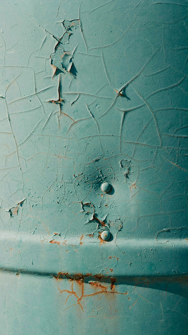 A close-up of a damaged camper exterior paint shows fading and peeling.