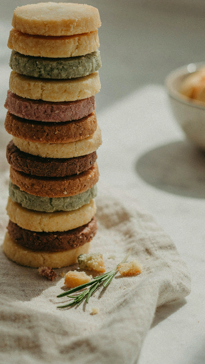 An asymmetrical stack of colorful shortbread cookies on linen.