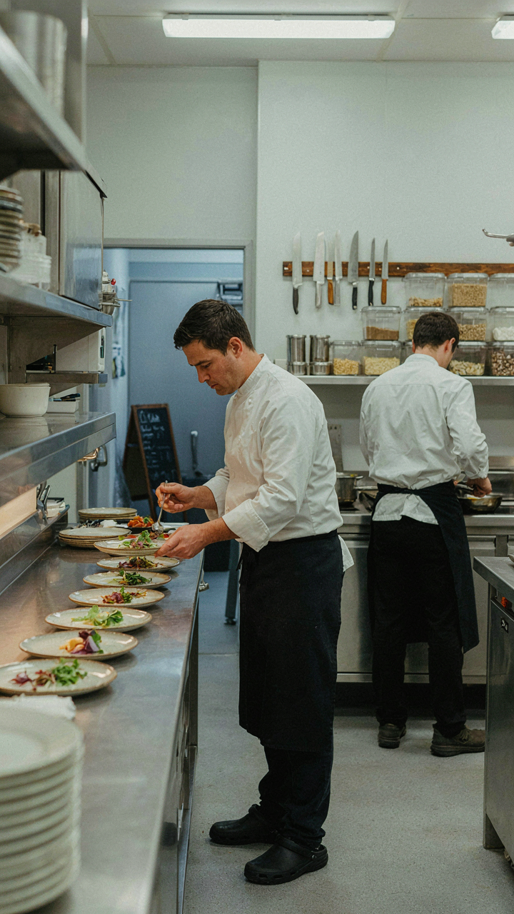 A chef moves smoothly in a small, organized kitchen.