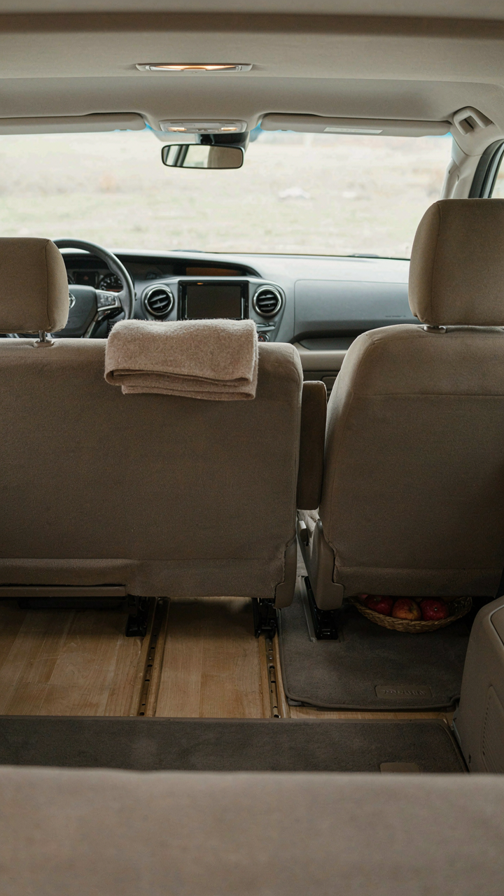 An empty, clean minivan interior with simple wooden panels.