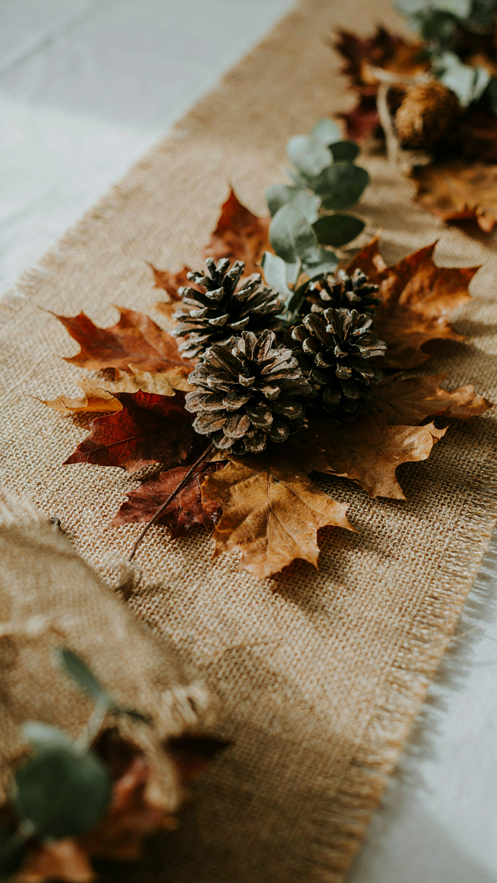 A close-up of a burlap table runner and a rustic wooden centerpiece.