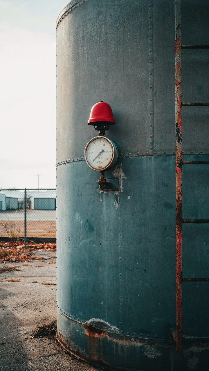 A gauge on a water tank shows a low level with a warning light.