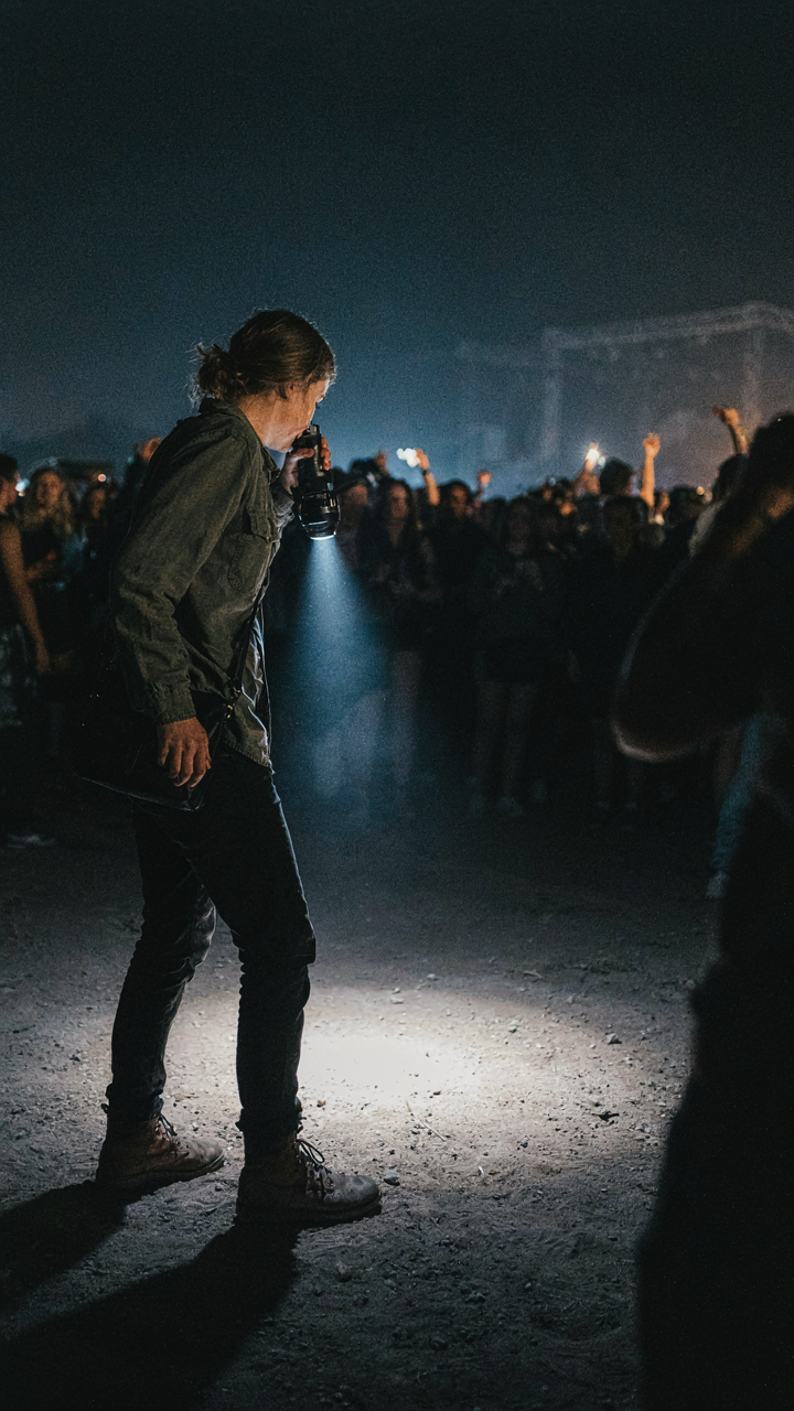 A person uses a headlamp to light a dark path.