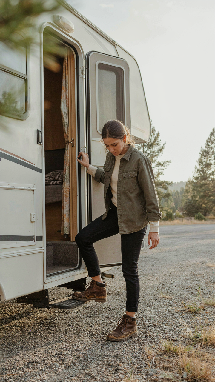 Person hesitates at RV door, deciding whether to enter with muddy boots.