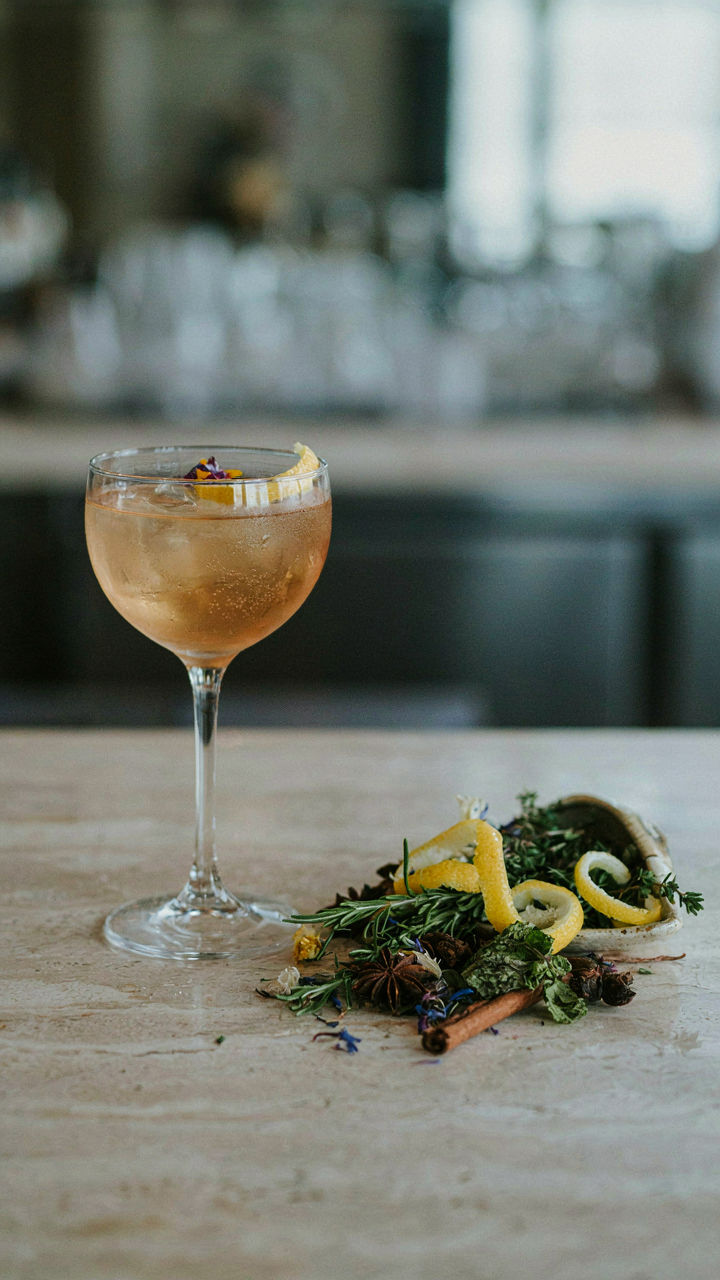An elegantly garnished mocktail next to a pile of excessive garnishes.