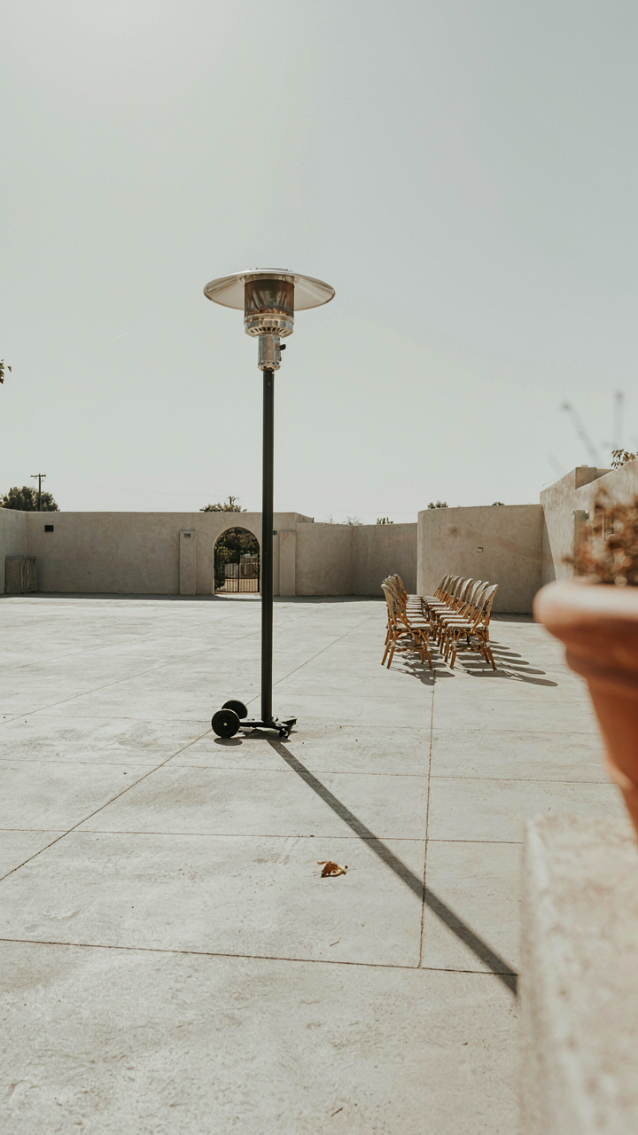 A single patio heater trying to warm a very large, open outdoor area.