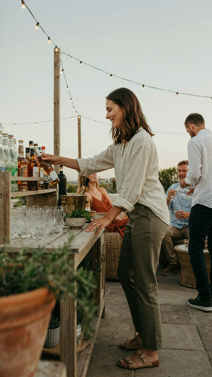 A smiling guest gets a drink from a beverage station on an outdoor patio.