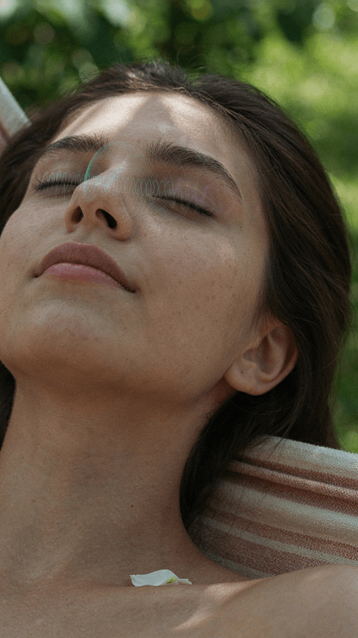 A person's serene face resting in a hammock, with brain wave patterns overlaid.