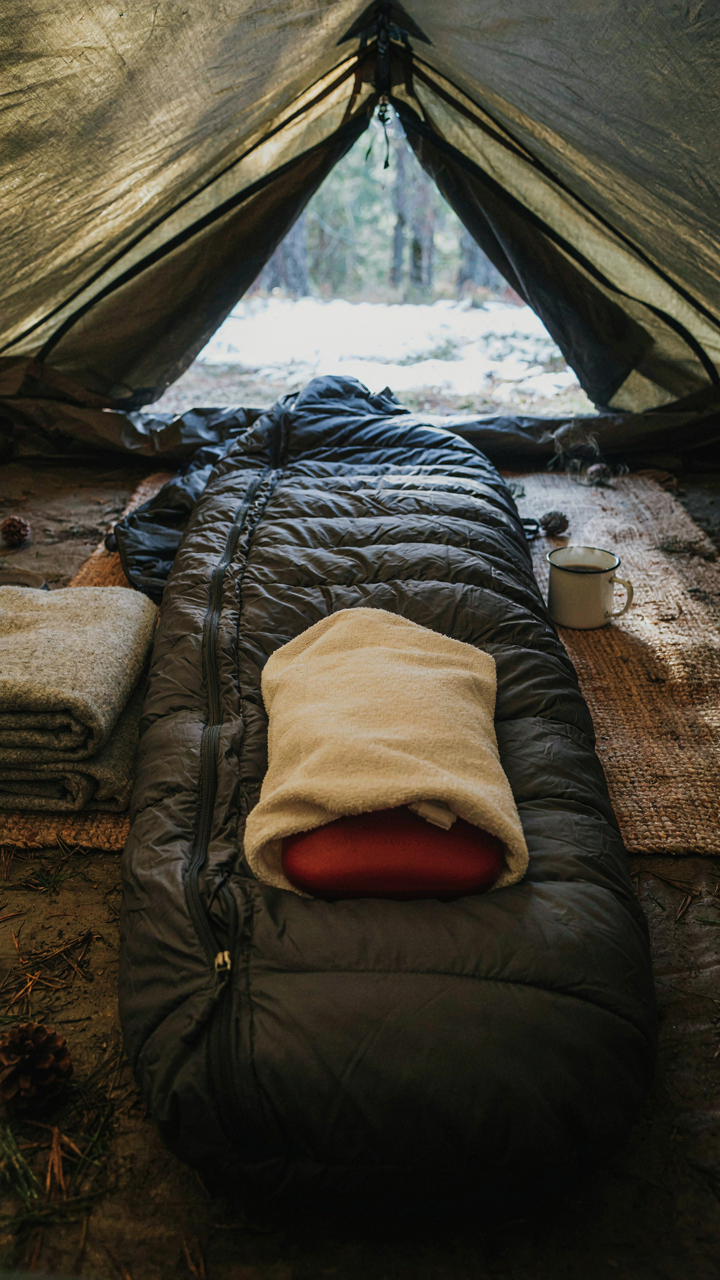 A hot water bottle sits in a sleeping bag, making it warm.