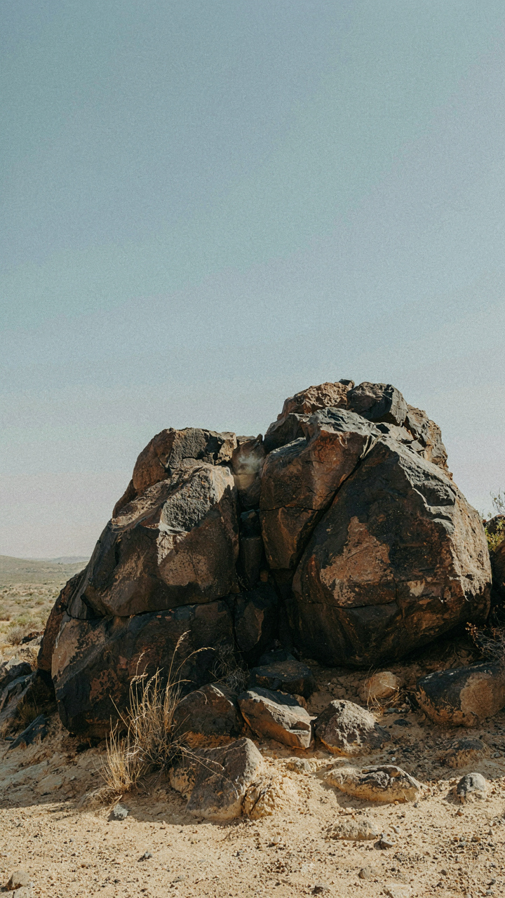 Large, dark rocks absorb sunlight on a warm day.