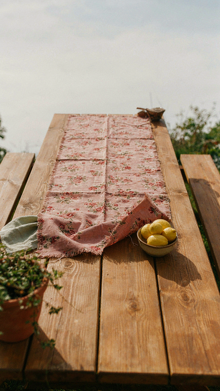 A poorly sewn fabric runner on a wooden picnic table.