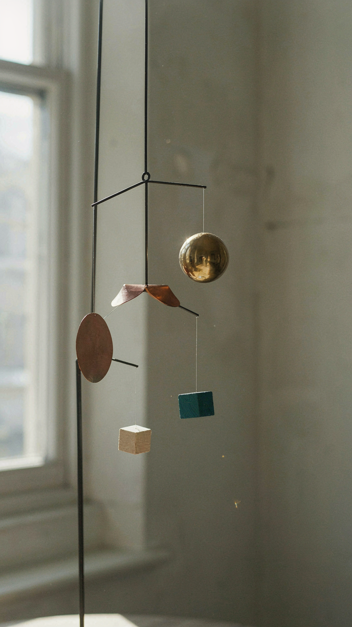 A delicate, balanced mobile sculpture hangs, showing principles of center of gravity.