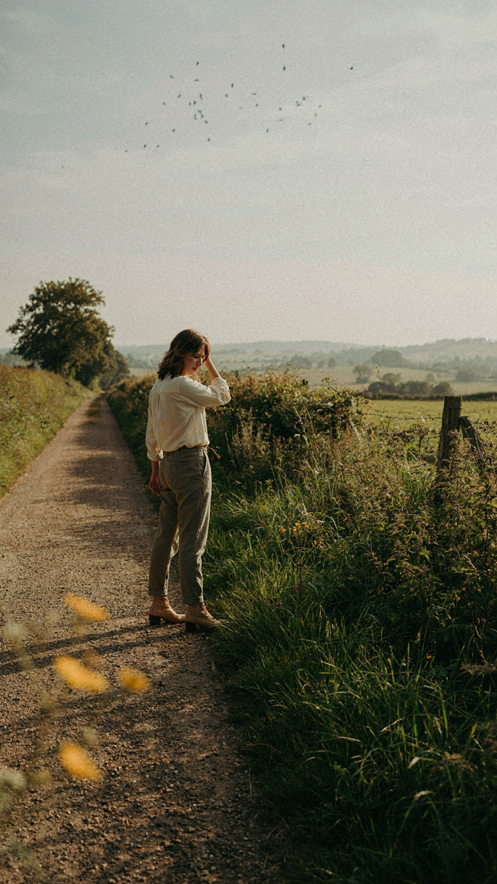 A person standing at a fork in a road, deciding which path to take.