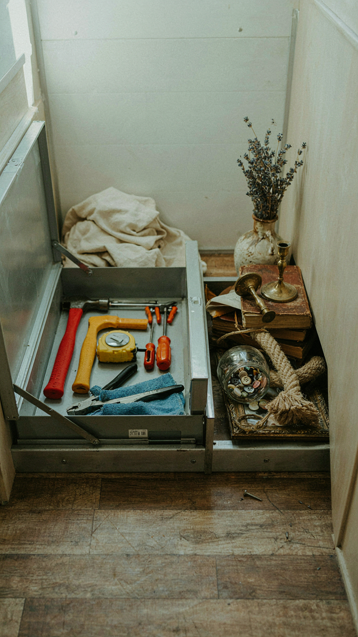 Essential tools neatly stored in an RV, next to a pile of decorative items.