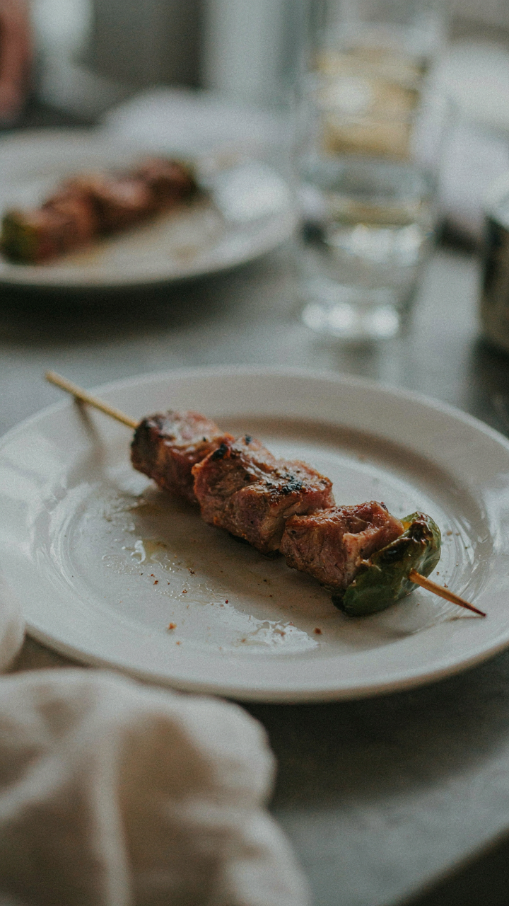 A poorly constructed skewer with ingredients falling off on a plate.