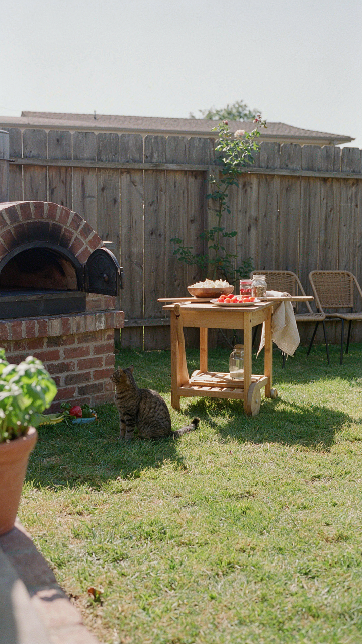 An outdoor pizza oven placed strategically in a backyard with a topping station.