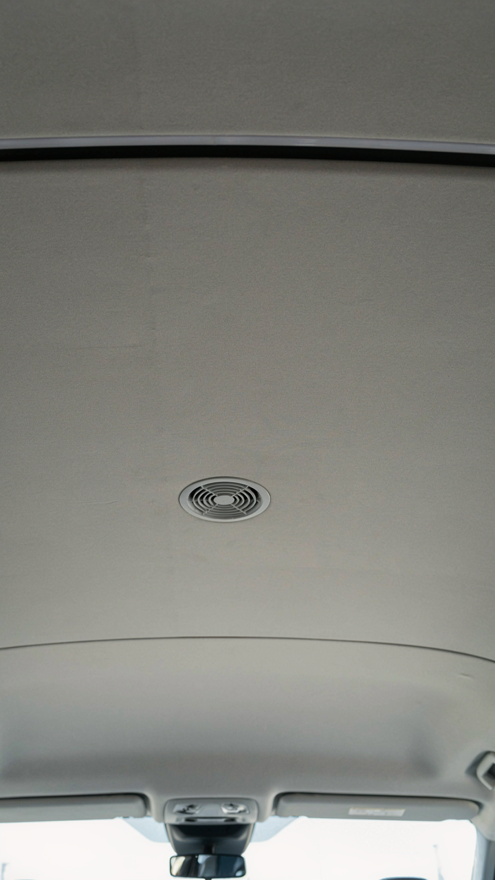 A clean, simple van ceiling with integrated LED lighting and a fan.