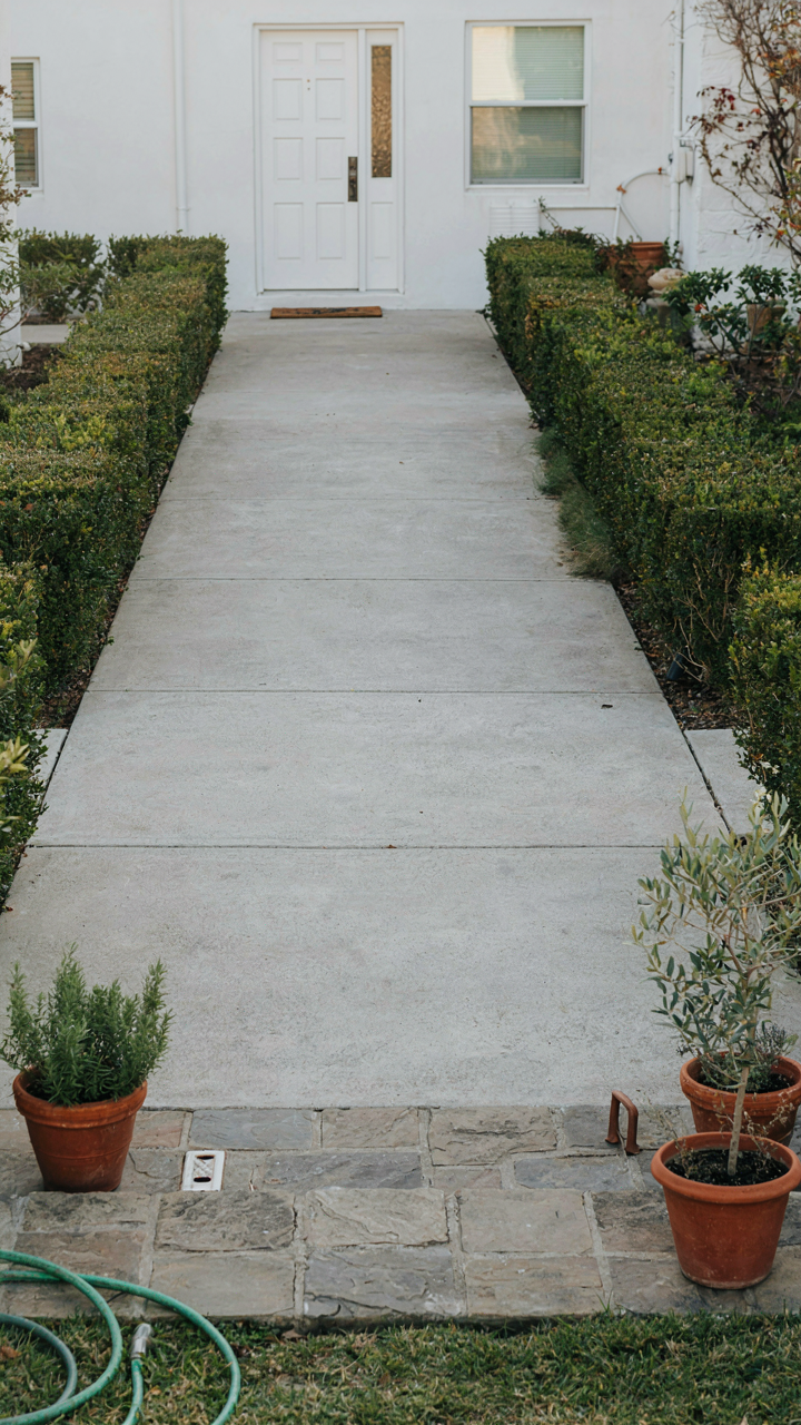 An open pathway from a house door leading to a corner patio.