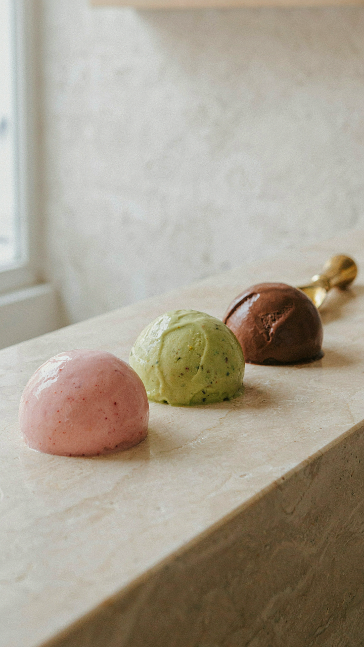A sleek gelato shop counter displays only three perfect gelato flavors.