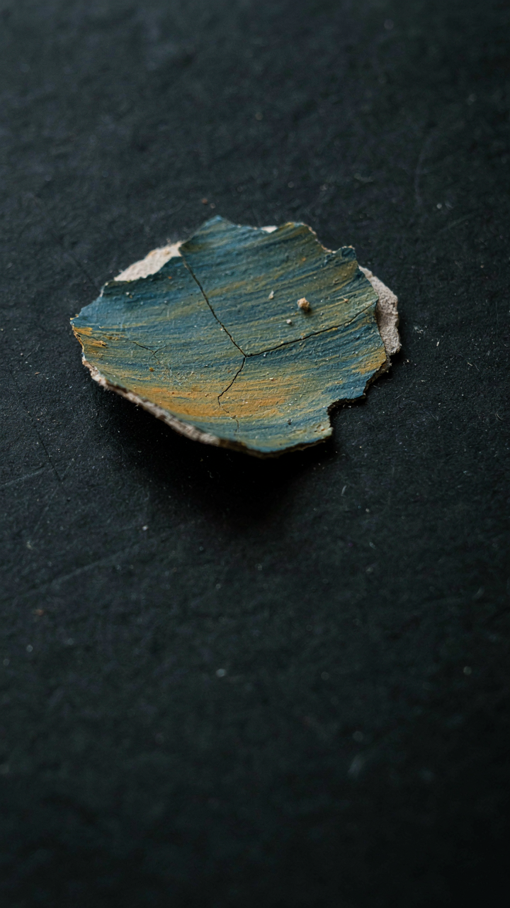 Close up of paint peeling off a surface, showing microscopic damage.