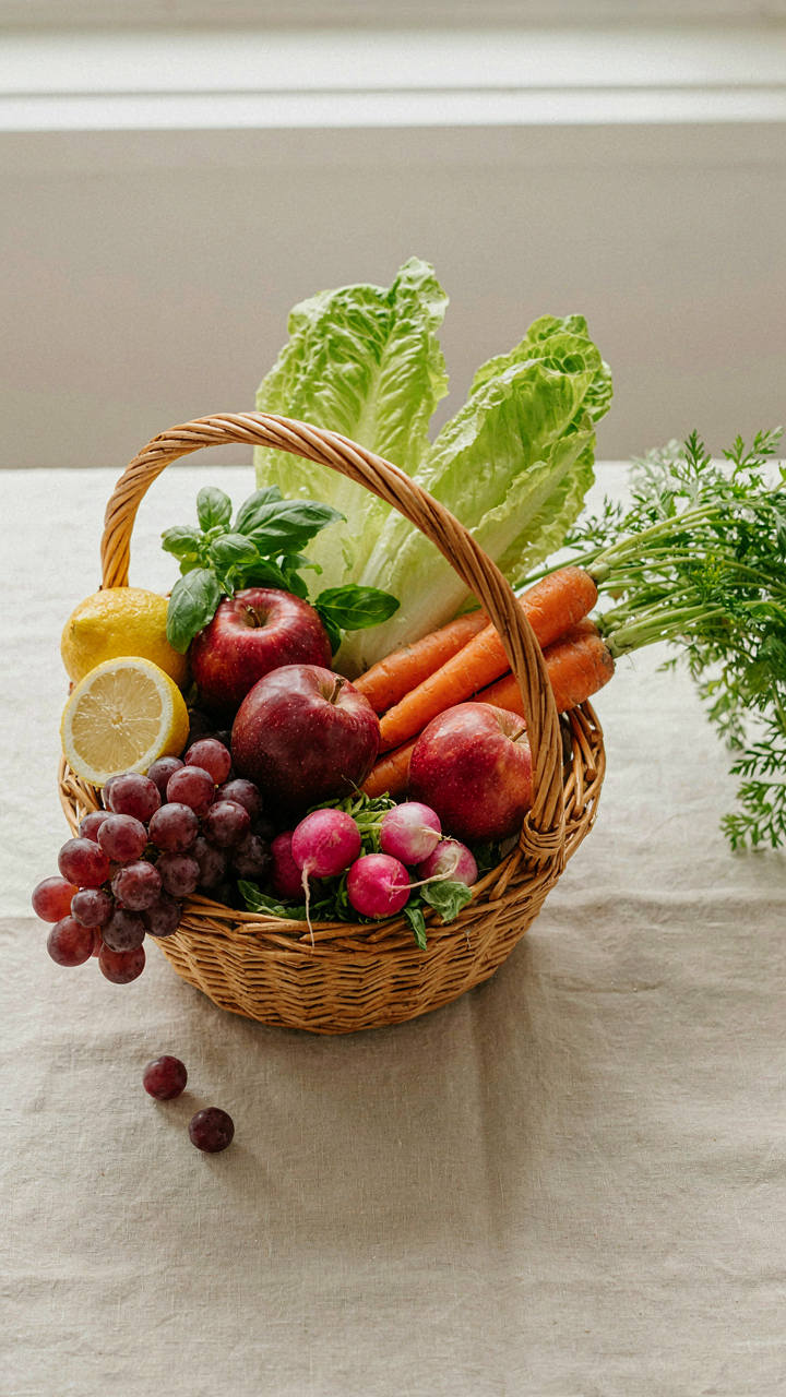 A wicker basket is filled with a beautiful and abundant arrangement of colorful fruits and