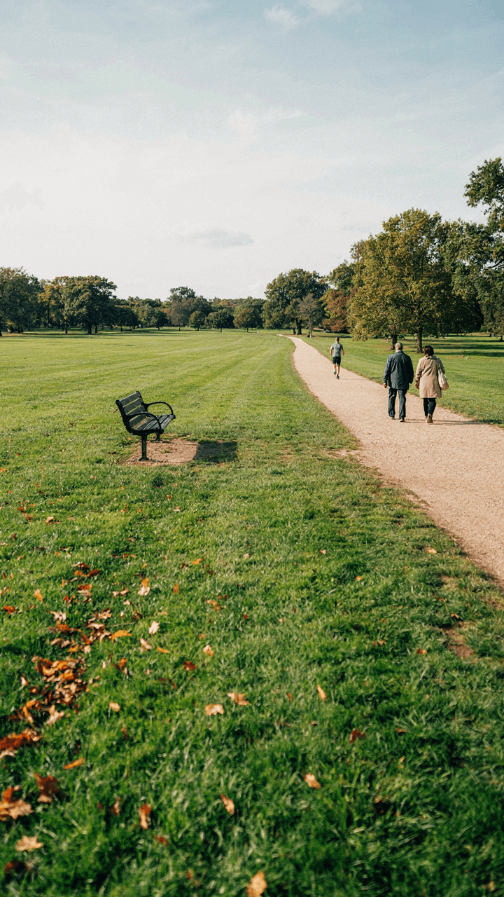 An empty park bench stands alone in a wide open space with no one sitting.