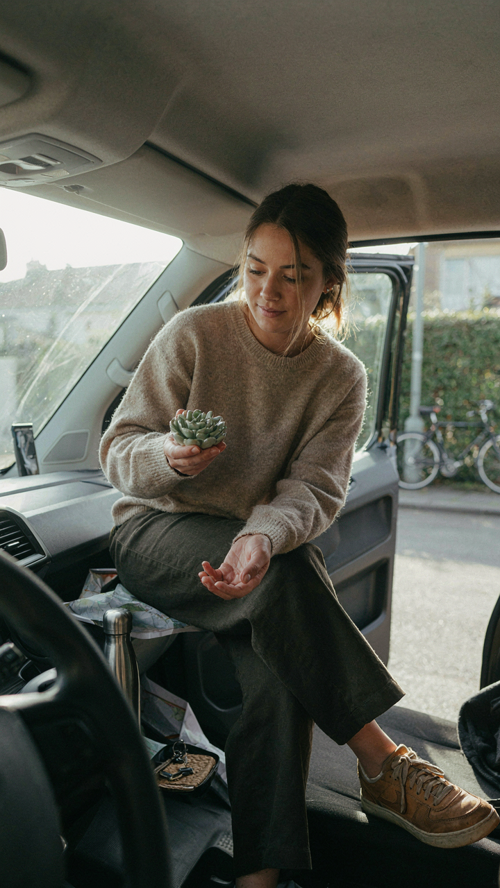 A person thoughtfully removing one small, unnecessary item from a van's interior.