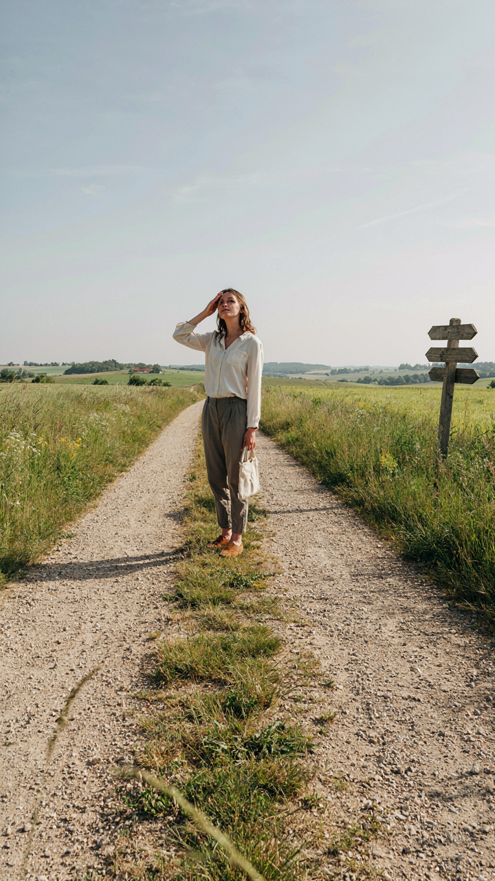 A person looks confused at a crossroads with too many paths.
