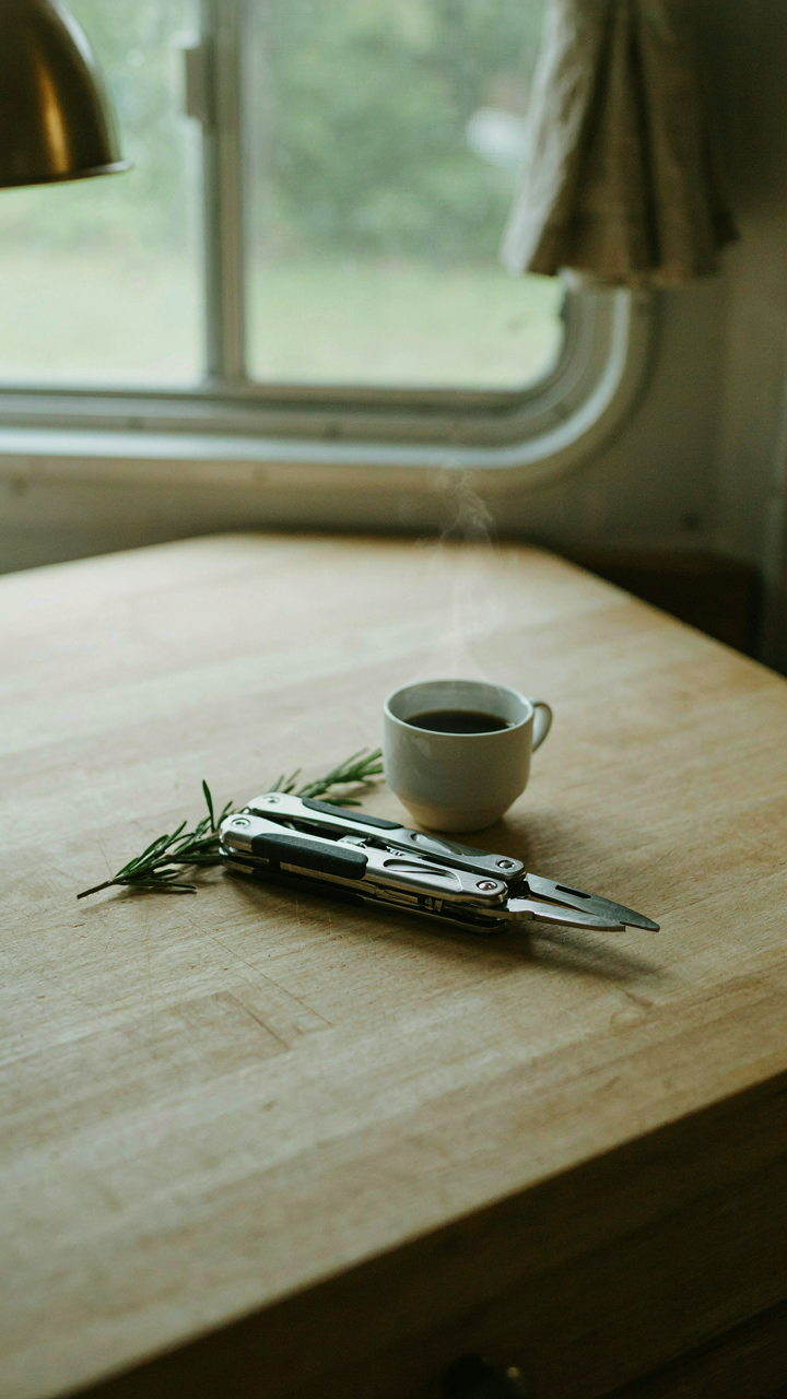 A multi-tool sits on a bus conversion kitchen counter.