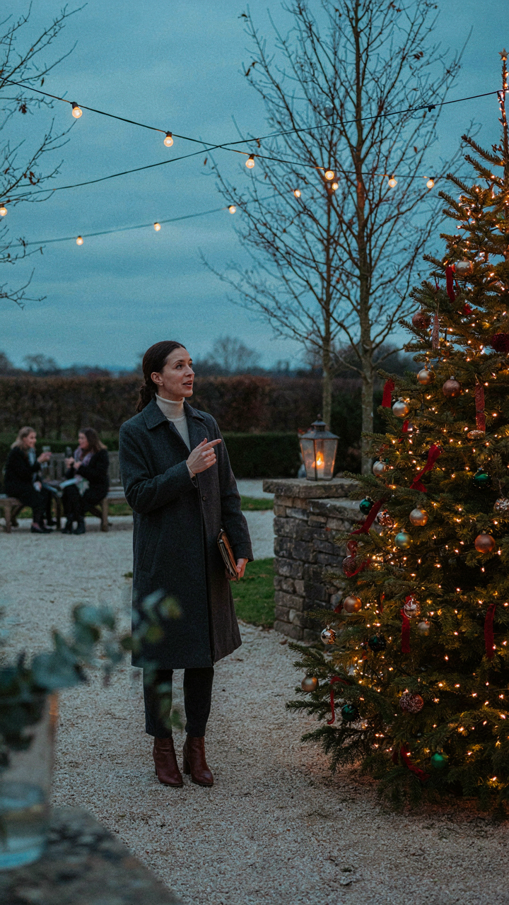 A landscape architect shows a main lit Christmas tree in a backyard.