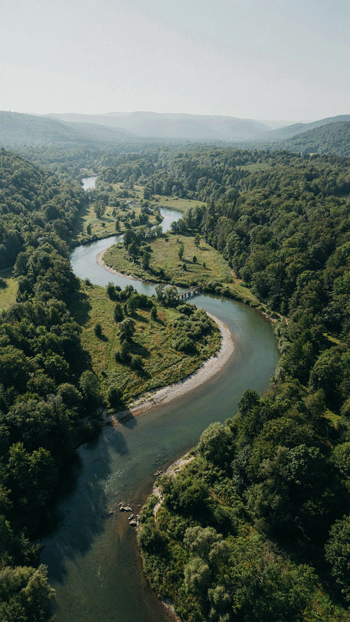 A smooth, winding river effortlessly carving a path through a landscape.