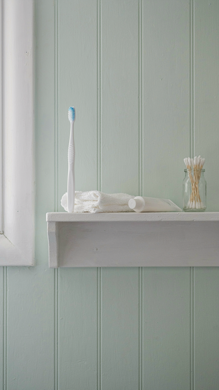 A single toothbrush and toothpaste sit neatly in an RV bathroom.