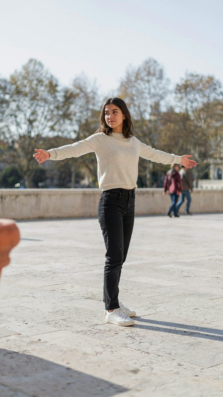 A person stands with arms out, showing clear space around them.