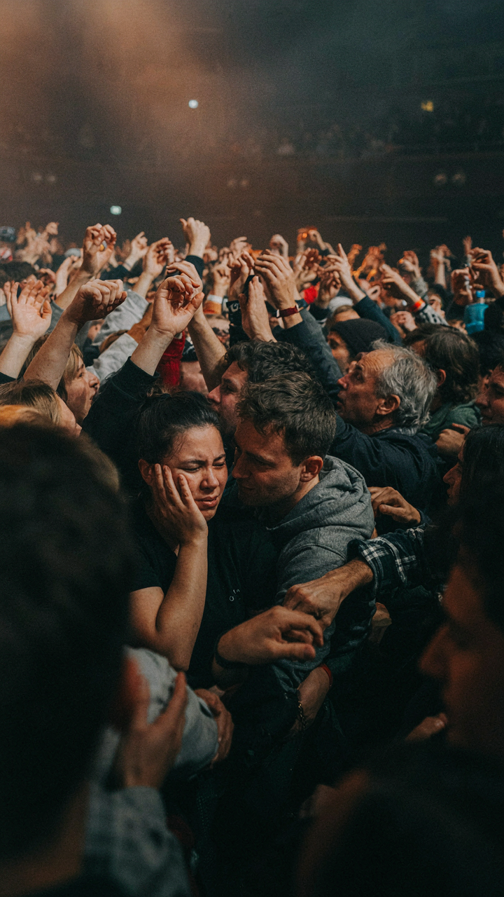 A crowded concert hall full of people shoulder to shoulder.