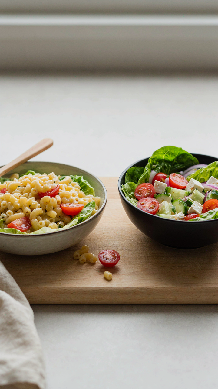 A sad, mushy pasta salad next to a fresh, crisp one in different bowls.