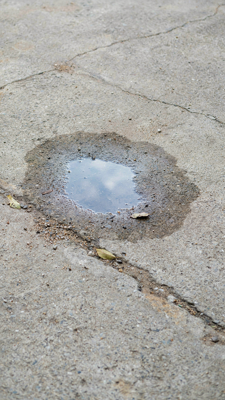 Water slowly soaks into a gray concrete surface.