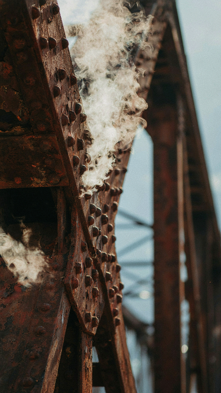 Steam rises from connection points on a metal bridge.