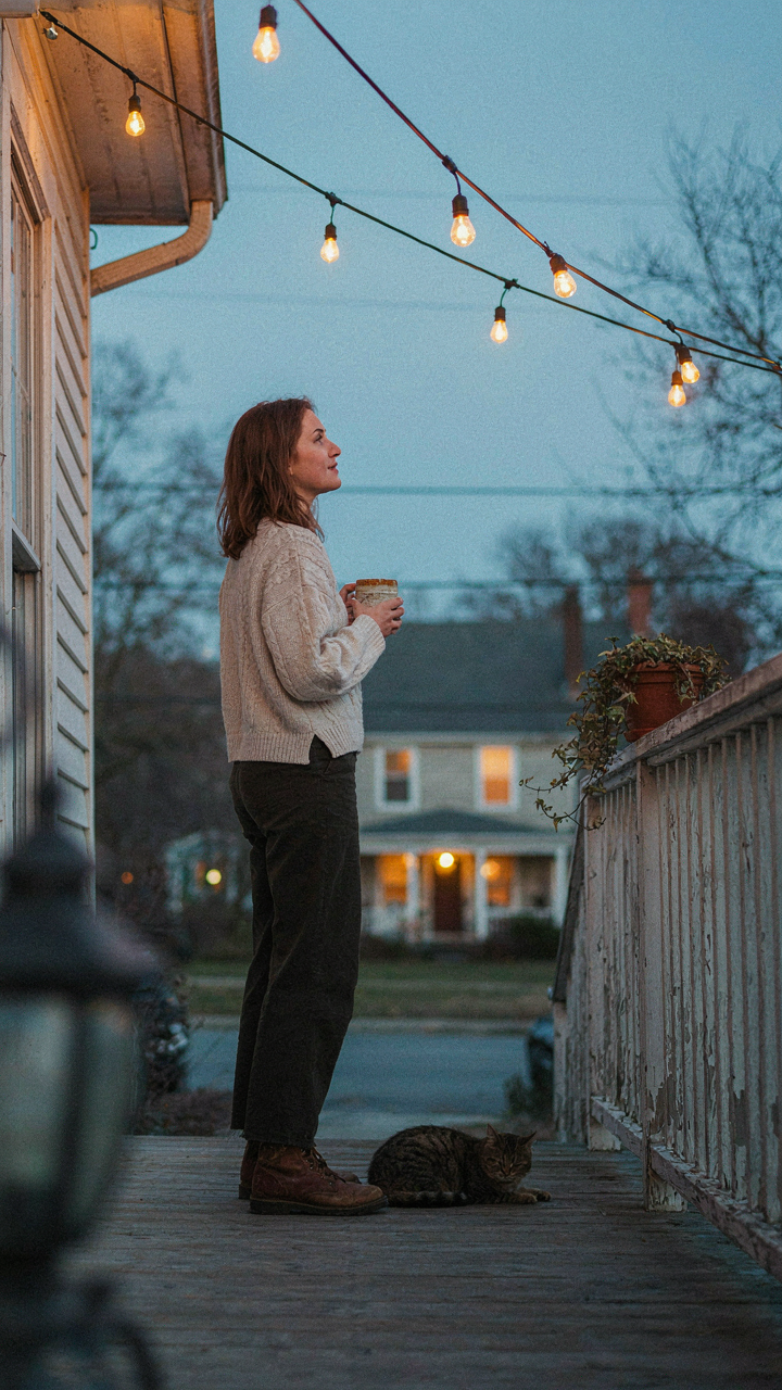 A person thoughtfully looks at outdoor string lights, considering their purpose.